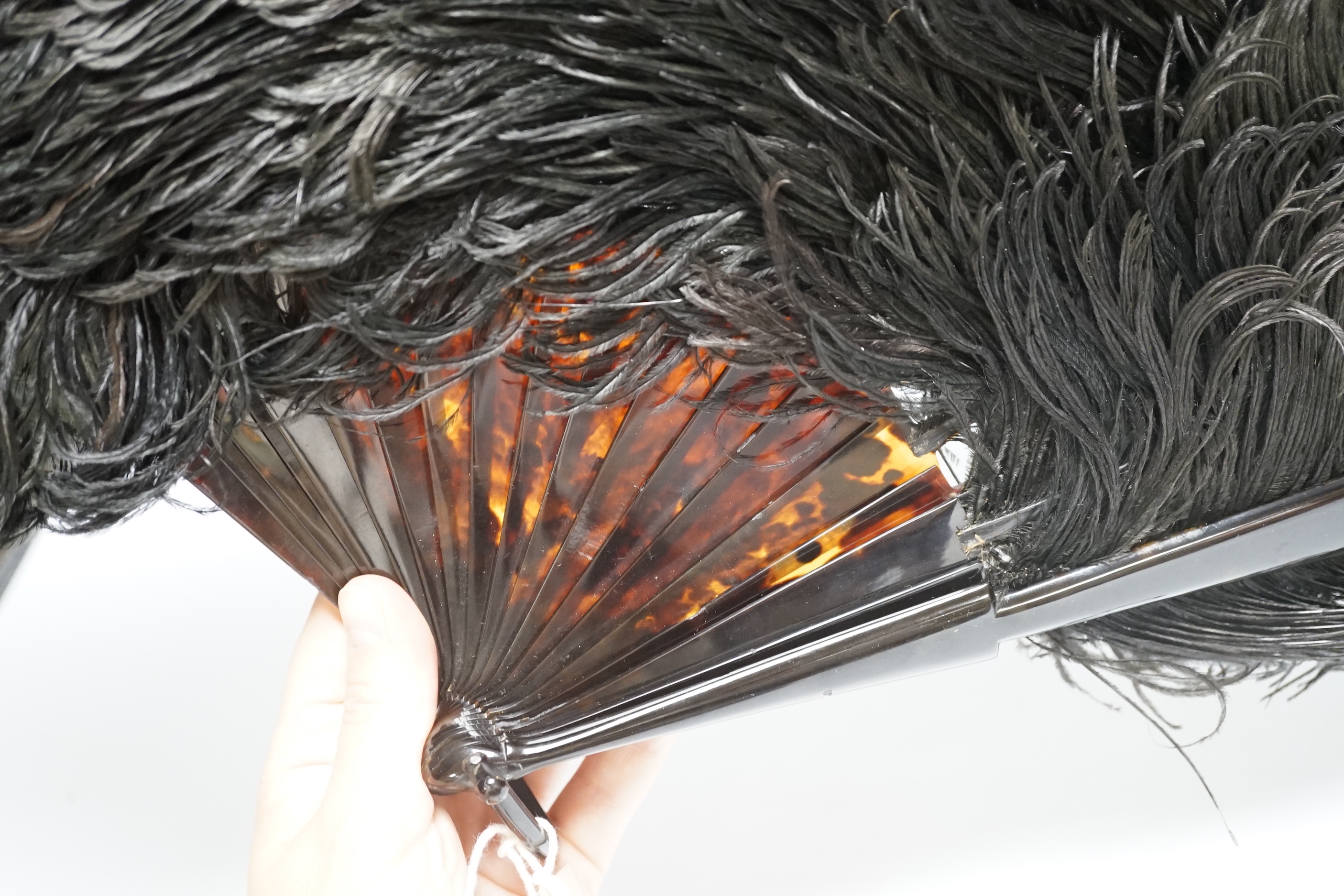 A large ostrich feather and faux tortoiseshell fan